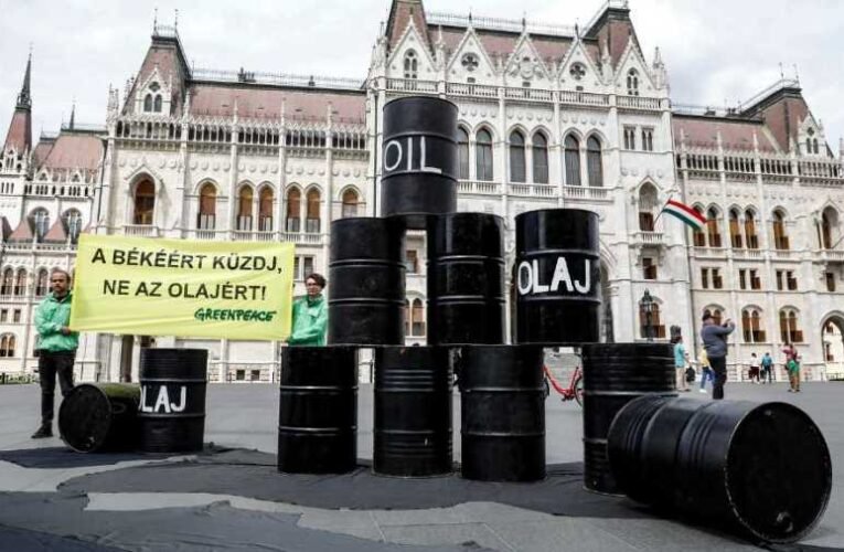 Néhány olajos hordót felállítva bohóckodik a Greenpeace a Kossuth téren