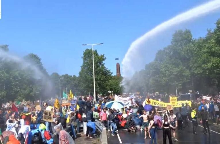 Tombolnak a környezetvédők Hágában, lezártak egy autópályát, majd előkerült a szivárványos zászló és a vízágyú is (videó)