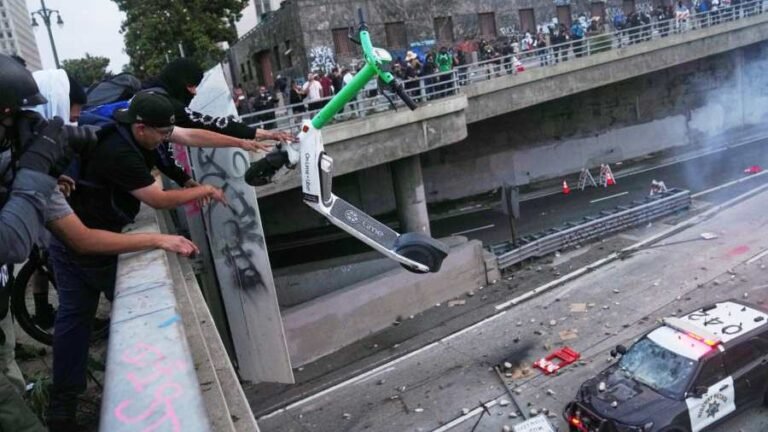 Kiemelt kép: Rollert dob egy rendőrautóra egy tüntető a Los Angeles belvárosában lévő börtön közelében (Fotó: MTI/AP/Jae C. Hong)