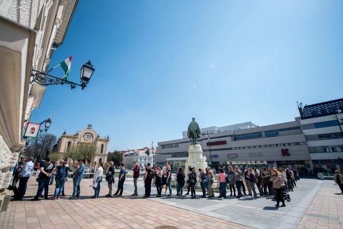 Ez a kép egészen briliáns! (Pécs, Kossuth tér) Mit látunk? Egy szabadkőműves szobra, a zsidó-templom és a Konzum előtt, kígyózik a tömeg. Minden szimbólum a helyen!