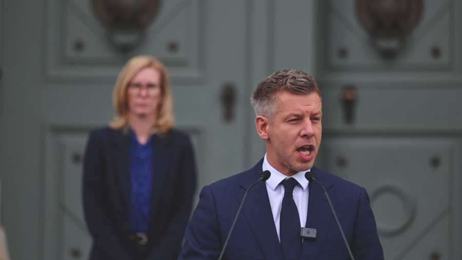 közjegyzői rendszer , Görög Márta megalázó helyzetben Magyar Péternek, a Tisza párt "szóvivőjének" a háta mögött.